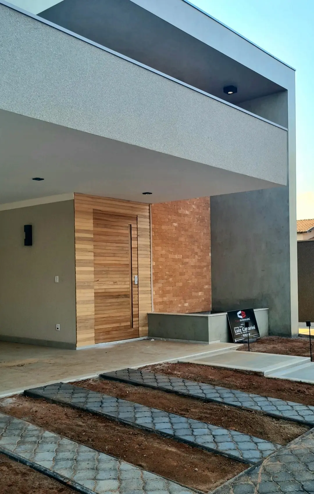 Entrada principal e acesso de autos à garagem; escada à residência — com acabamentos concluídos de porta, paredes e pisos. Entrada de autos e calçadas com piso intertravados. Garagem e escada em piso porcelanato e soleiras em granito.Condomínio Jardim Botânico