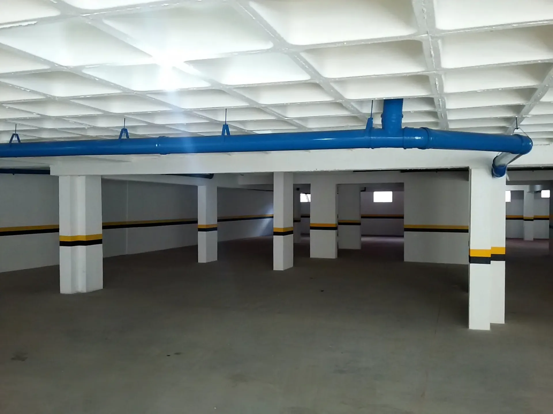 Garagem do  Edifício Fênix Acabamento de piso, pintura de paredes e tubulações.Sinalizações:
demarcações nas paredes.